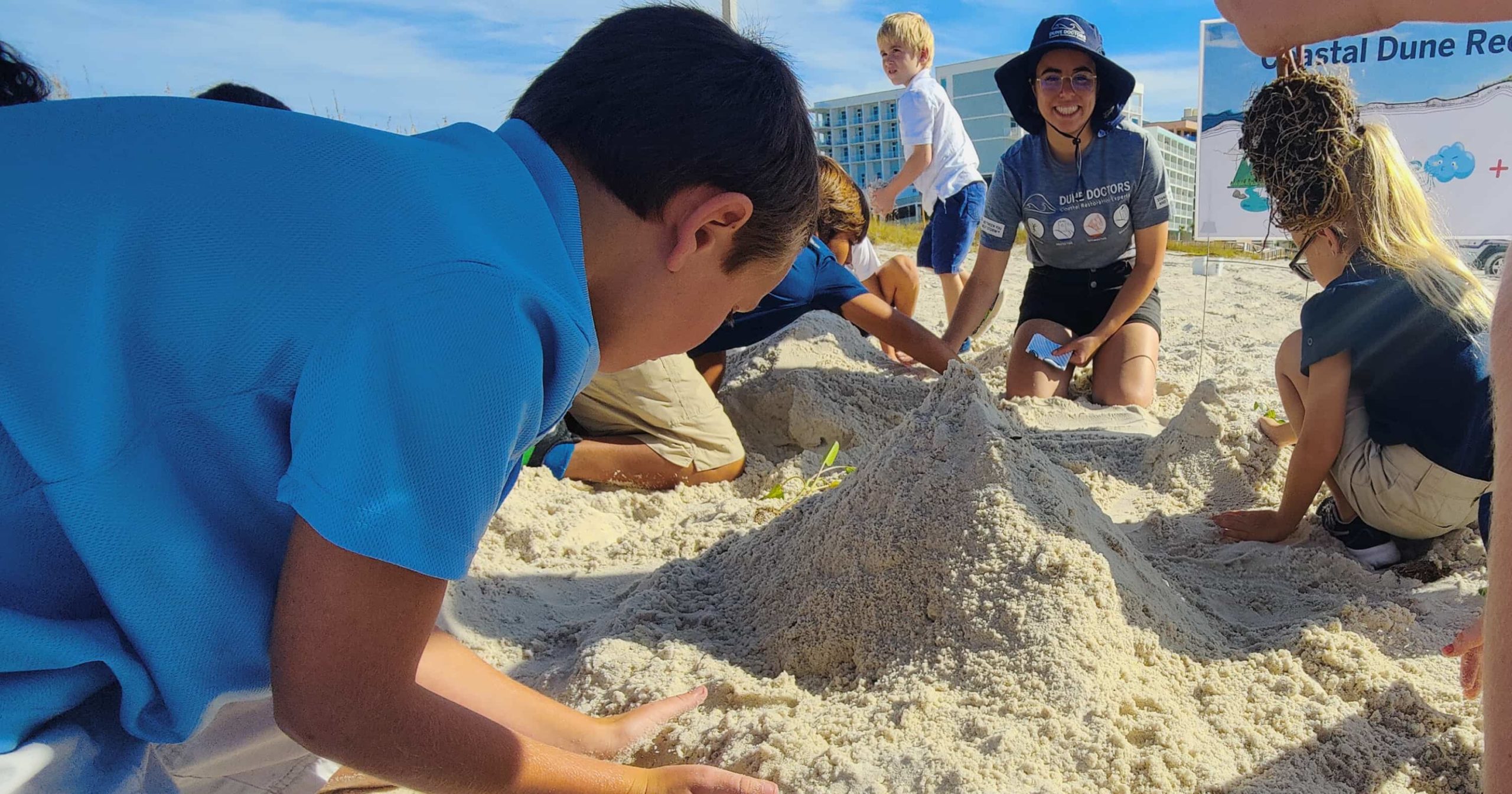 A group of students try to build a coastal dune with their hands