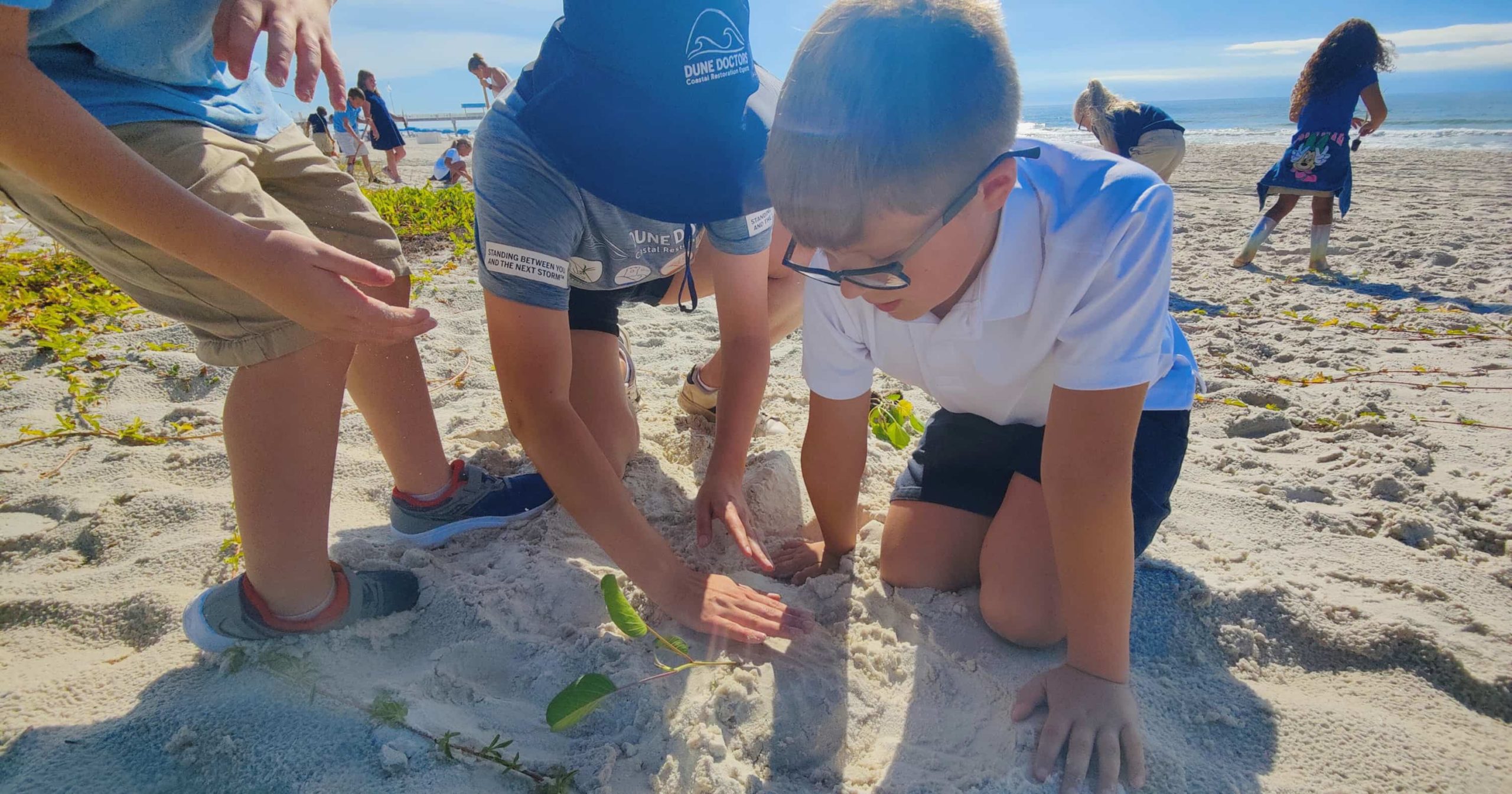 Orange Beach, AL elementary students plant a native sea oat