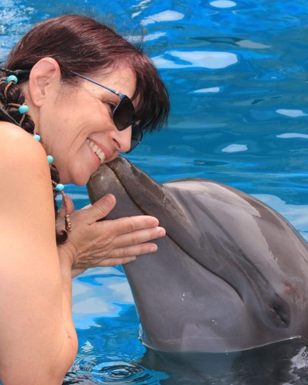 Lori Raisch receives a kiss from a dolphin